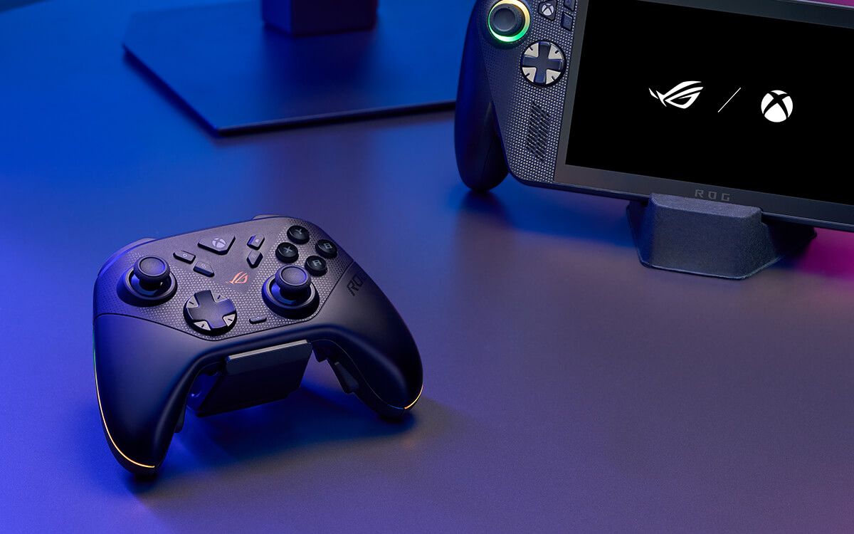 Manette de jeu noire et PC portable avec accents lumineux sur un bureau sombre.