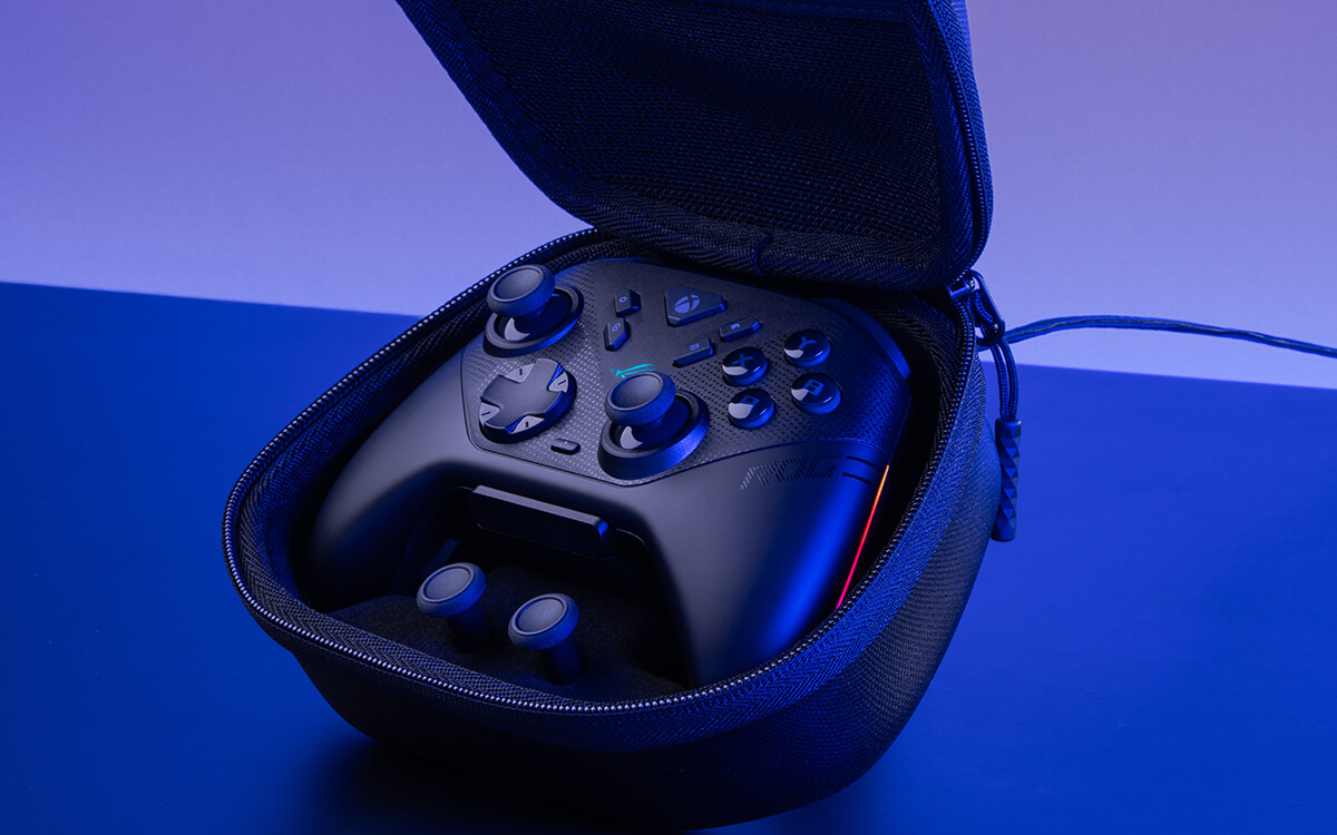 Manette de jeu noire dans un étui noir ouvert, éclairée par une lumière bleue et violette.