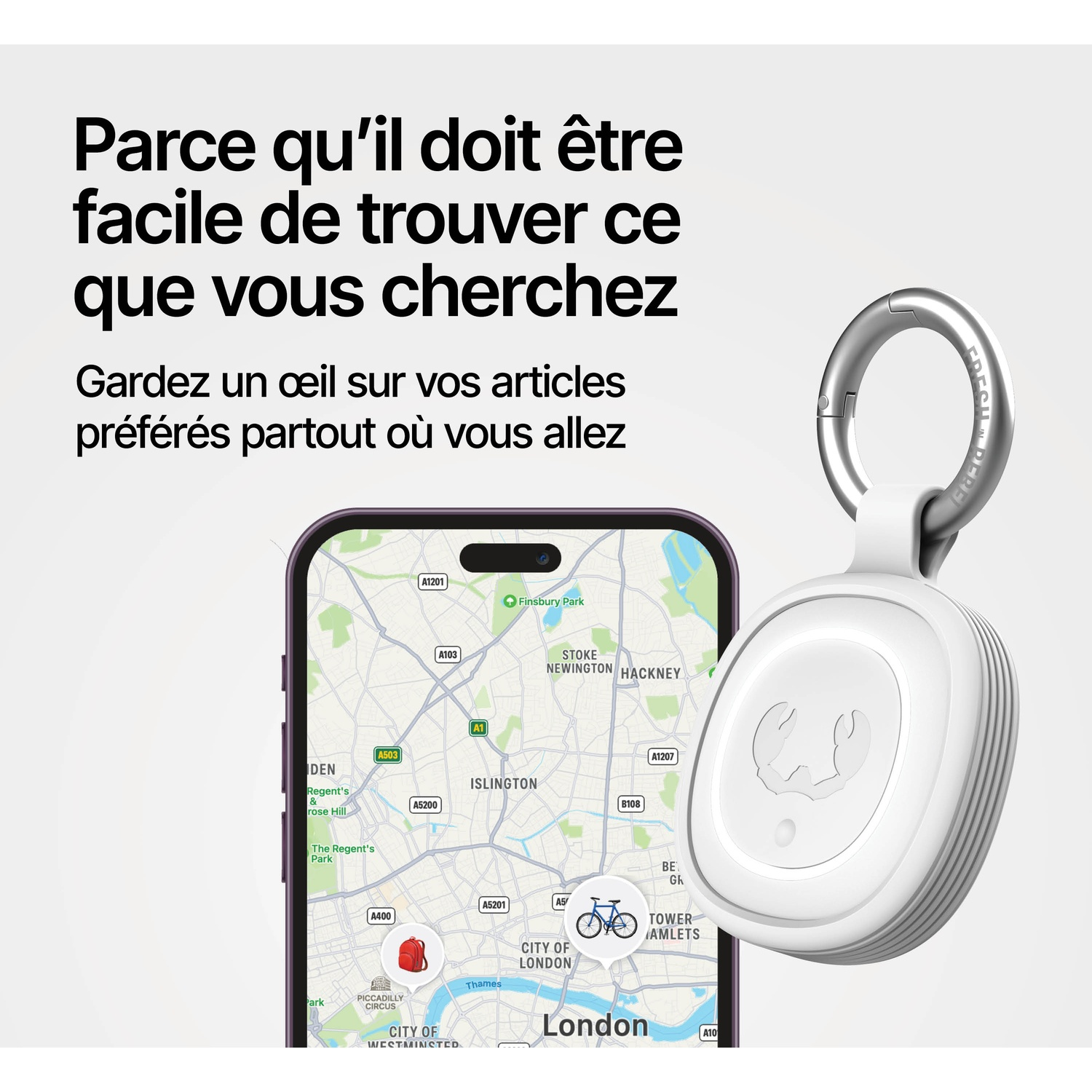 Un traqueur blanc avec un porte-clés à côté d'un smartphone affichant une carte de Londres.