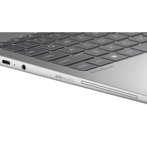 Primer plano de un teclado plateado de portátil con puertos USB-C y de audio.