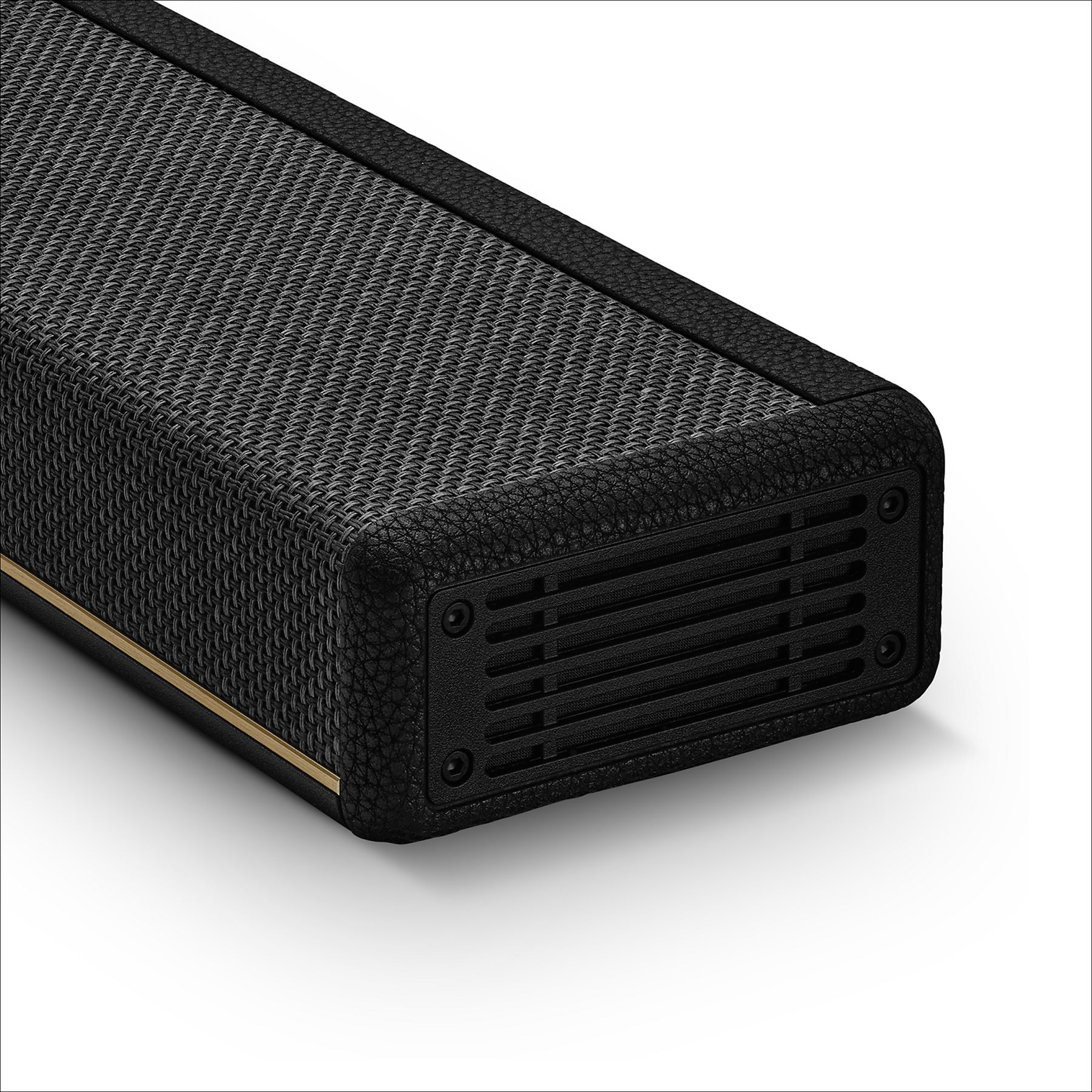 Altavoz negro con rejilla y textura de cuero, acento dorado.