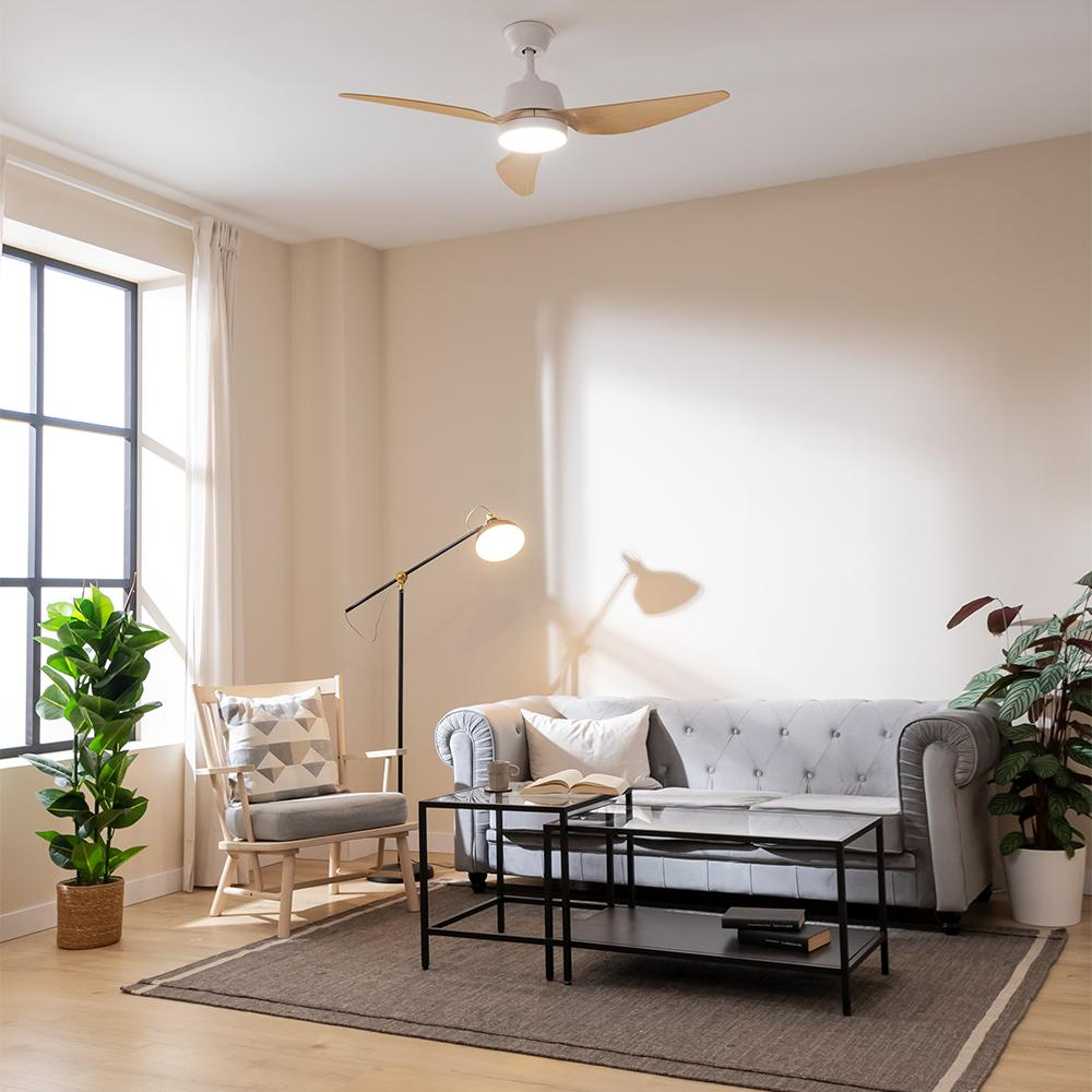 Una sala de estar luminosa con un sofá gris, dos mesas de centro y un sillón.