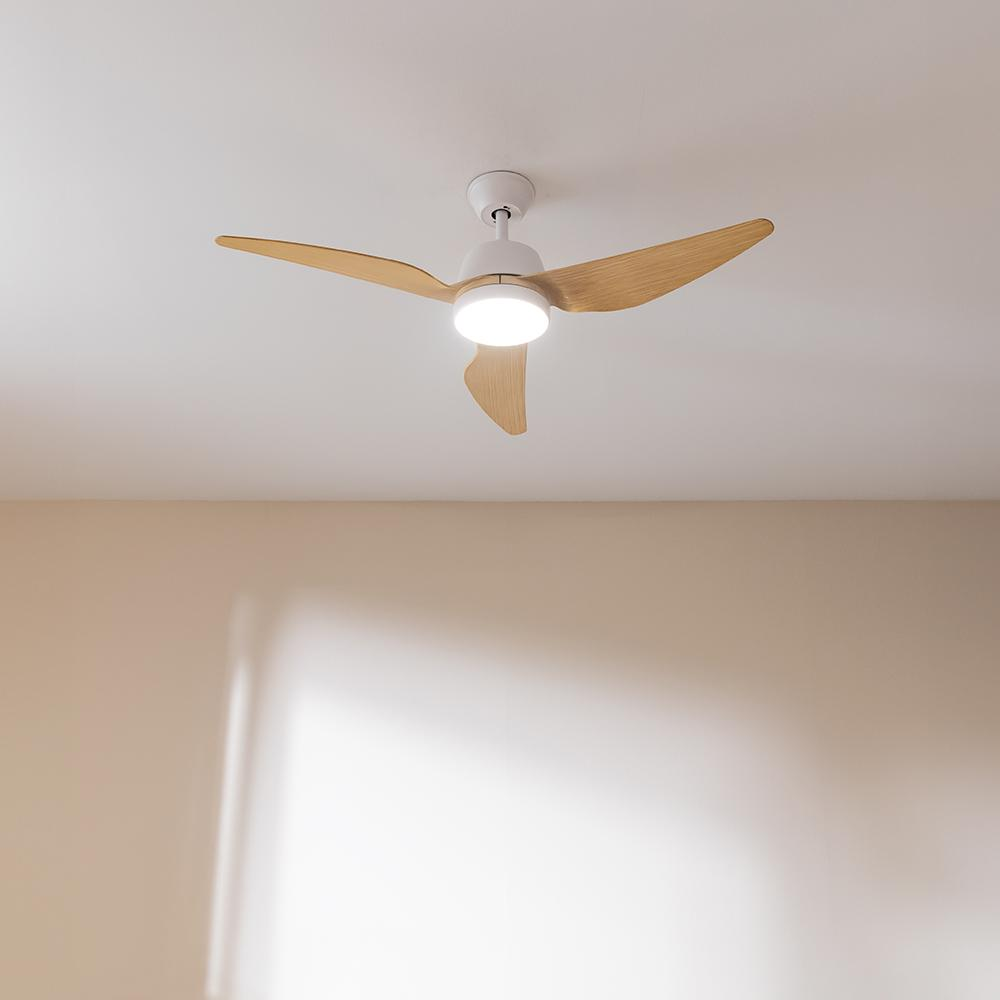 Un ventilador de techo blanco con tres aspas de madera y luz integrada.