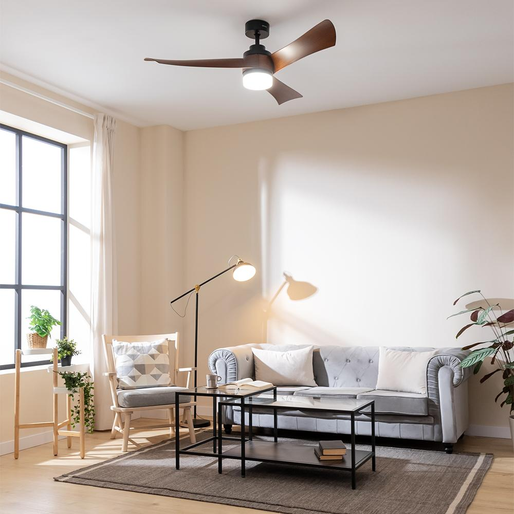 Una sala de estar con sofá, sillón, mesas de centro, lámpara y ventilador de techo.