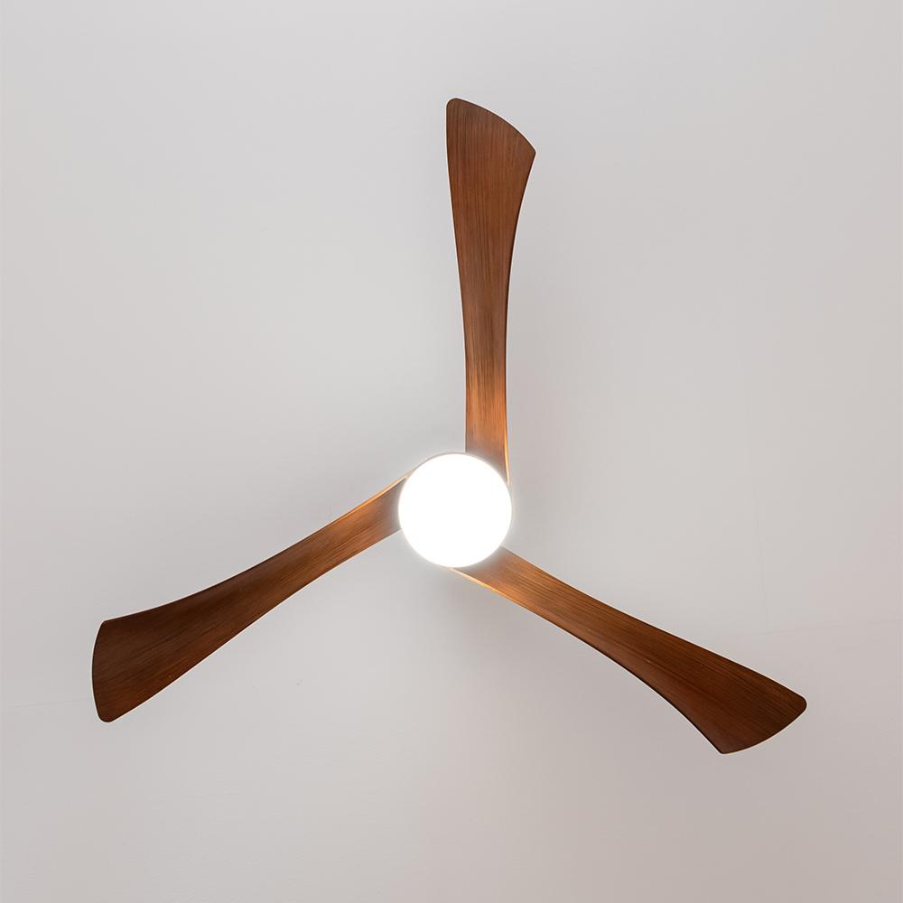 Un ventilador de techo de madera de tres aspas con una luz redonda en el centro.