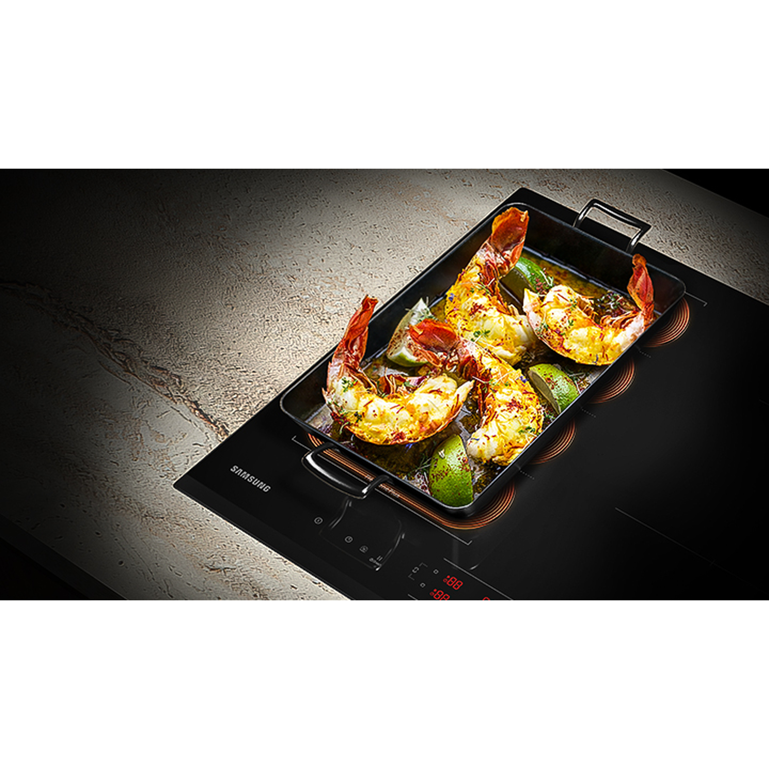 Grilled shrimp with lime wedges in a pan on a black induction stovetop.
