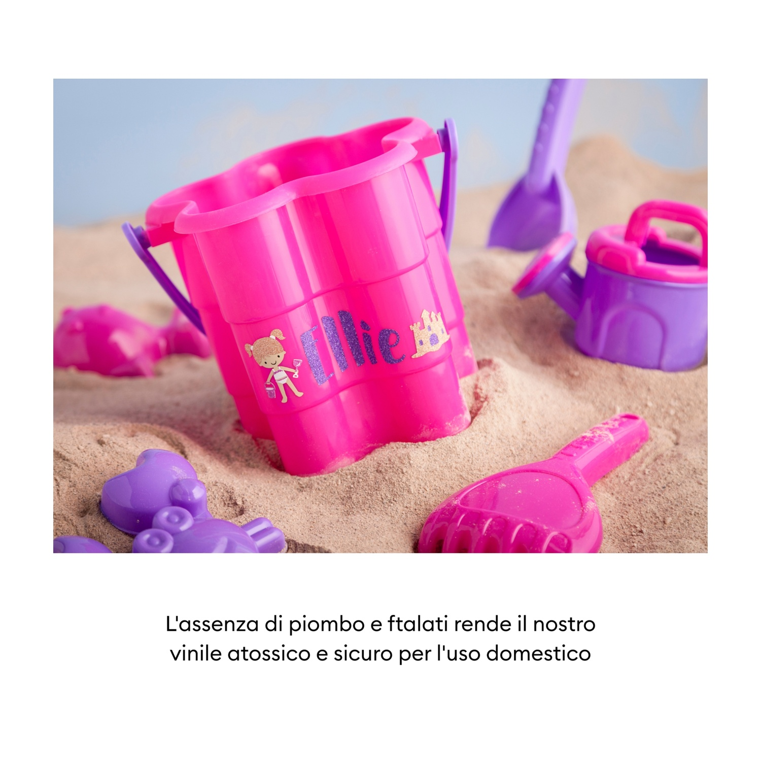 Giochi da spiaggia colorati, tra cui secchiello, annaffiatoio e formine, sulla sabbia.
