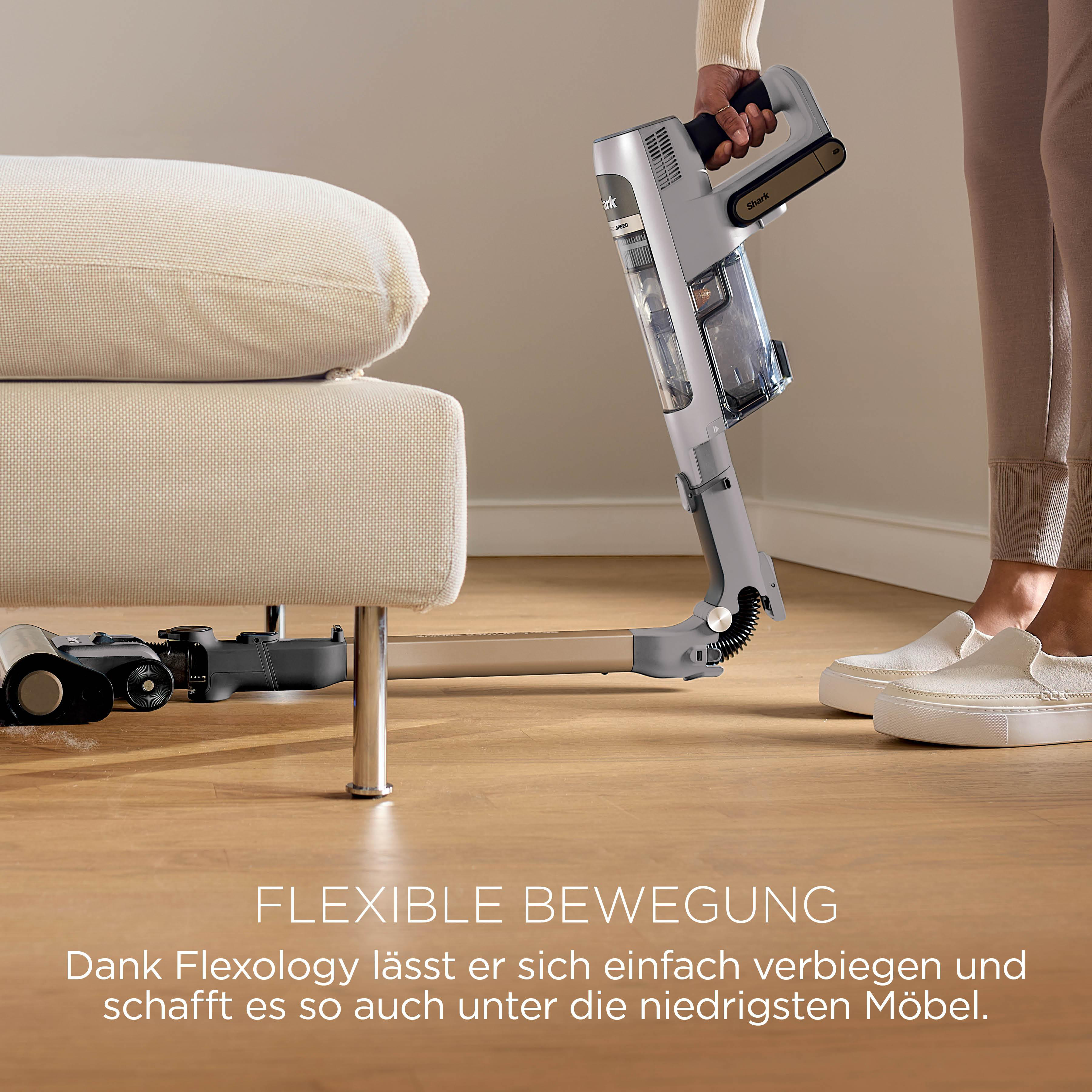Ein Handstaubsauger wird unter ein Sofa geschoben, um Staub zu saugen.