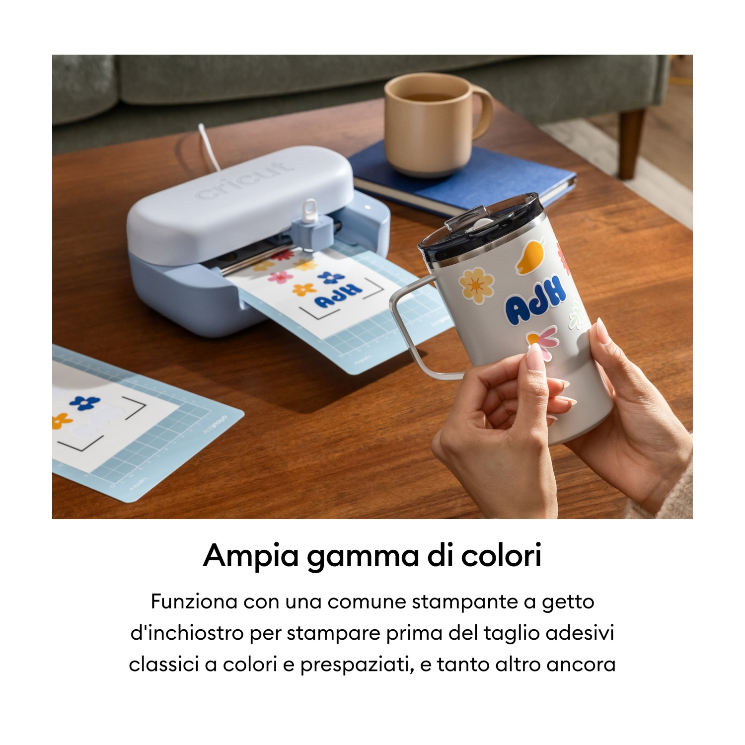 Una persona decora una tazza con adesivi mentre una macchina Cricut taglia adesivi.
