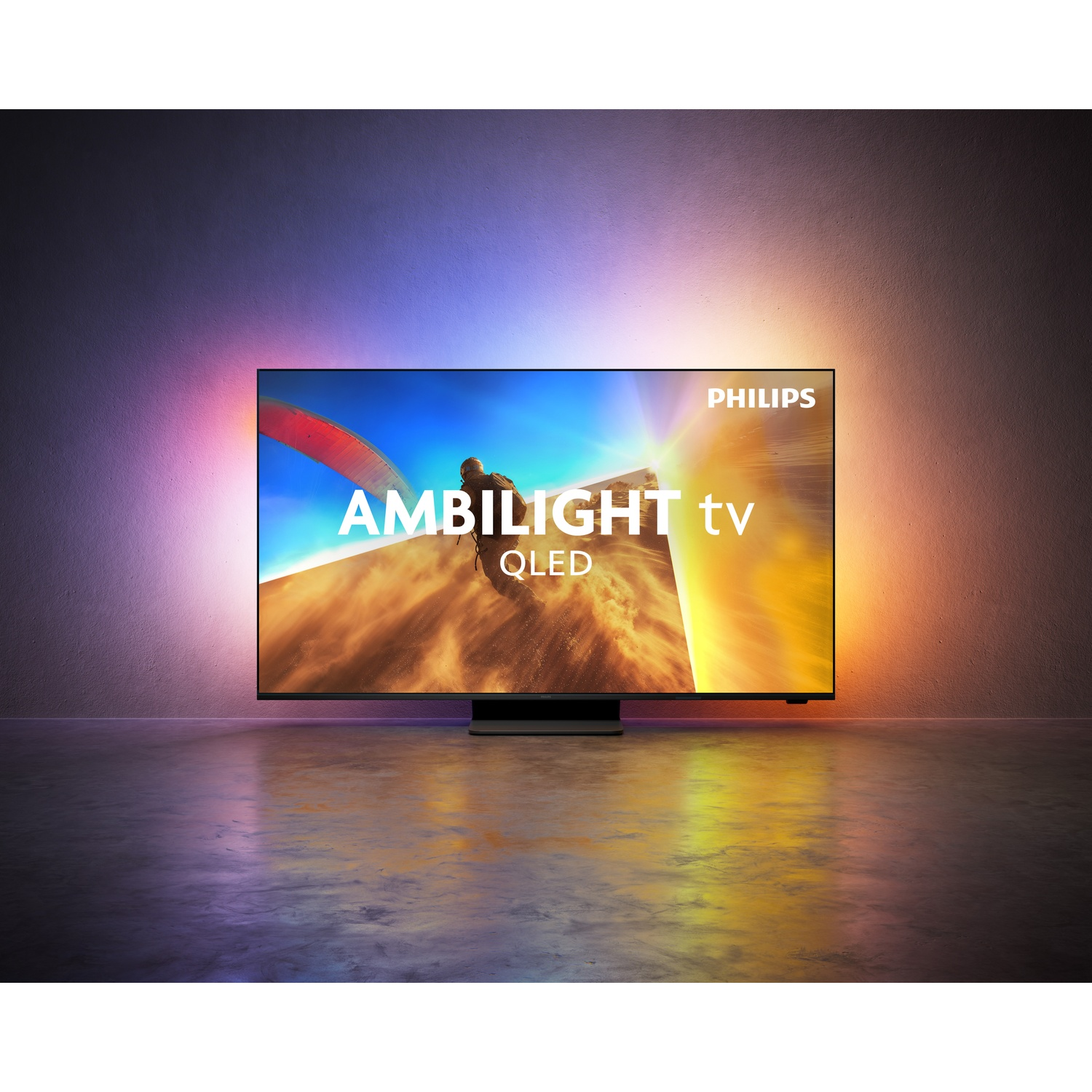 A Philips Ambilight TV with QLED technology, displaying an image of a paraglider.