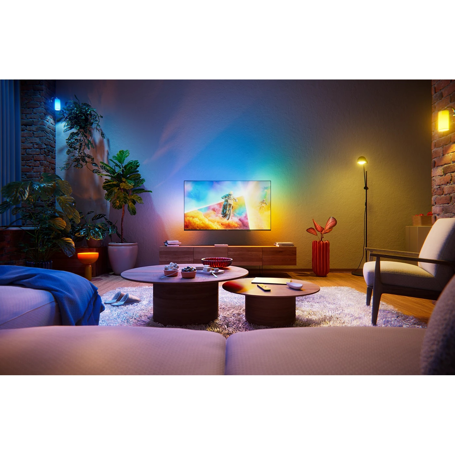 Living room with colorful ambient lighting on wall, TV, plants, and furniture.