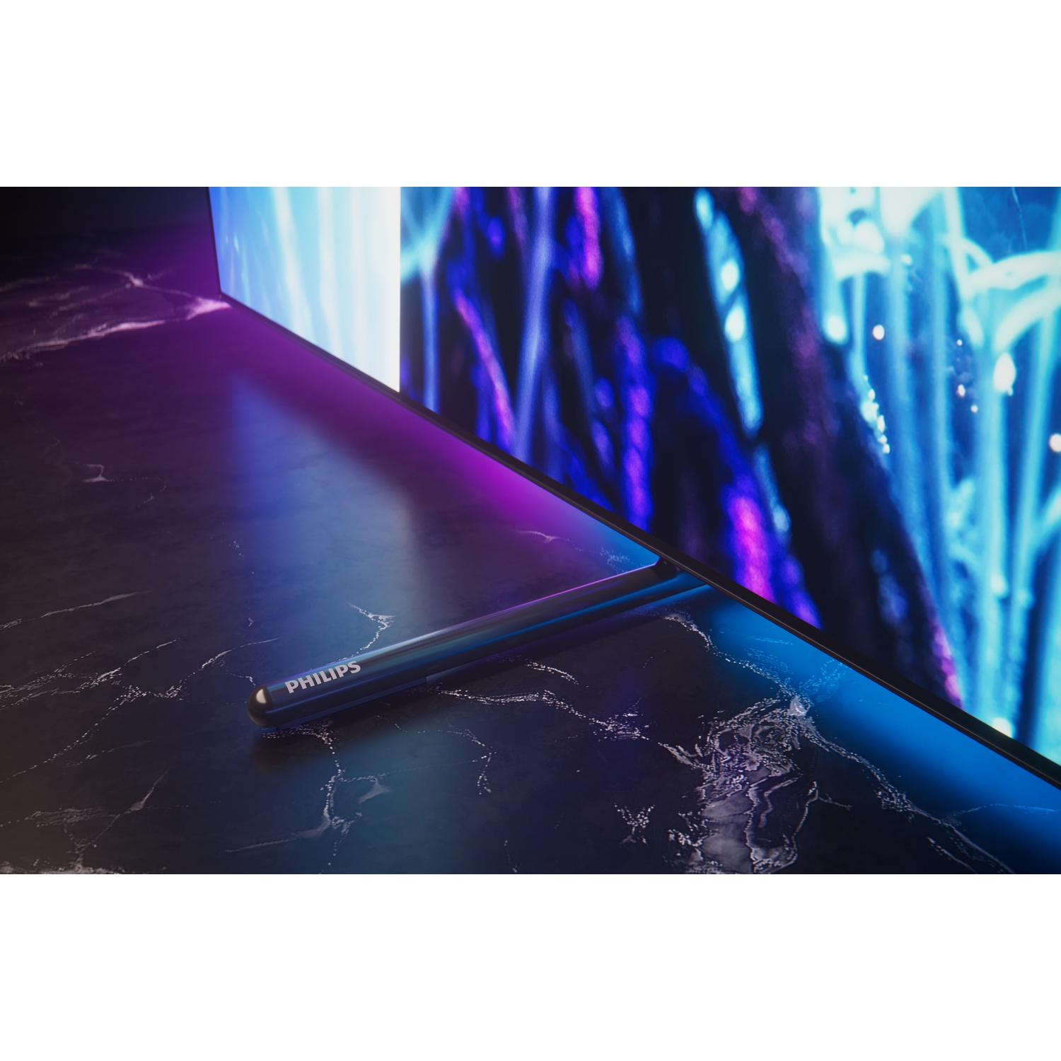 Une TV Philips avec Ambilight repose sur une table en marbre. Lumières violettes et bleues.