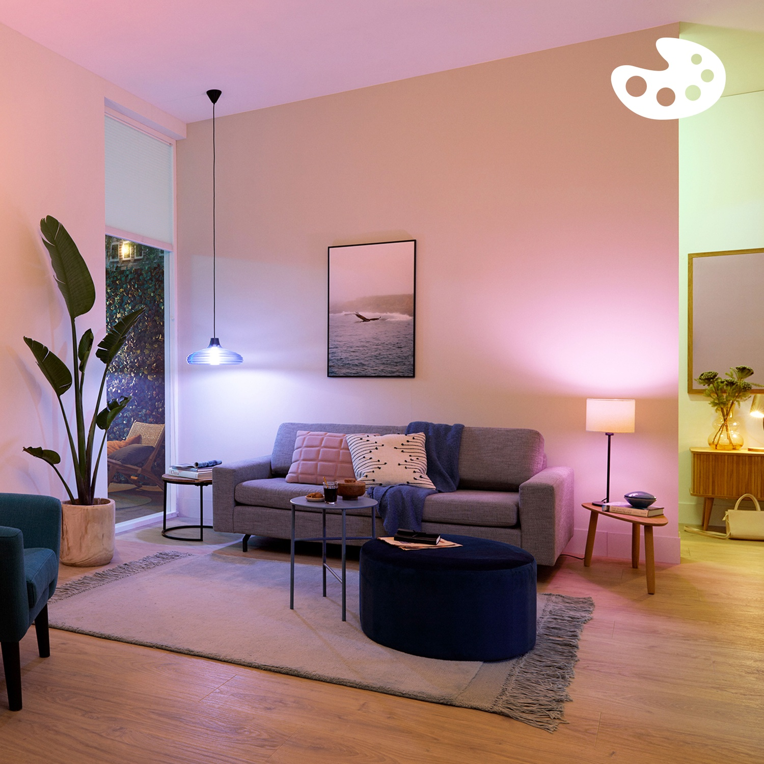 Salon avec canapé, lampe et plantes, éclairé en lumière rose et verte.