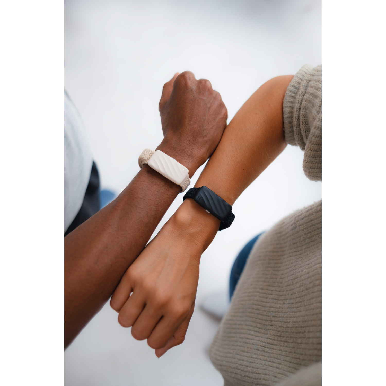 Twee mensen, één met donkere huid, één met lichte huid, tonen hun smartwatches.