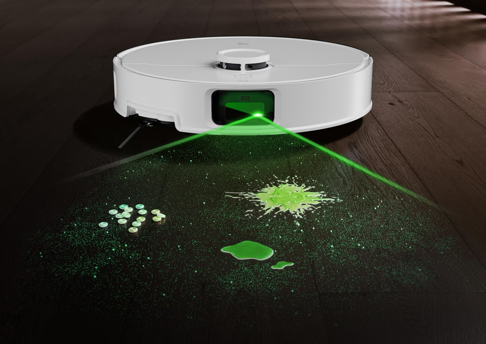 Un robot aspirapolvere bianco proietta linee laser verdi su un pavimento in legno scuro con una fuoriuscita di liquido verde.