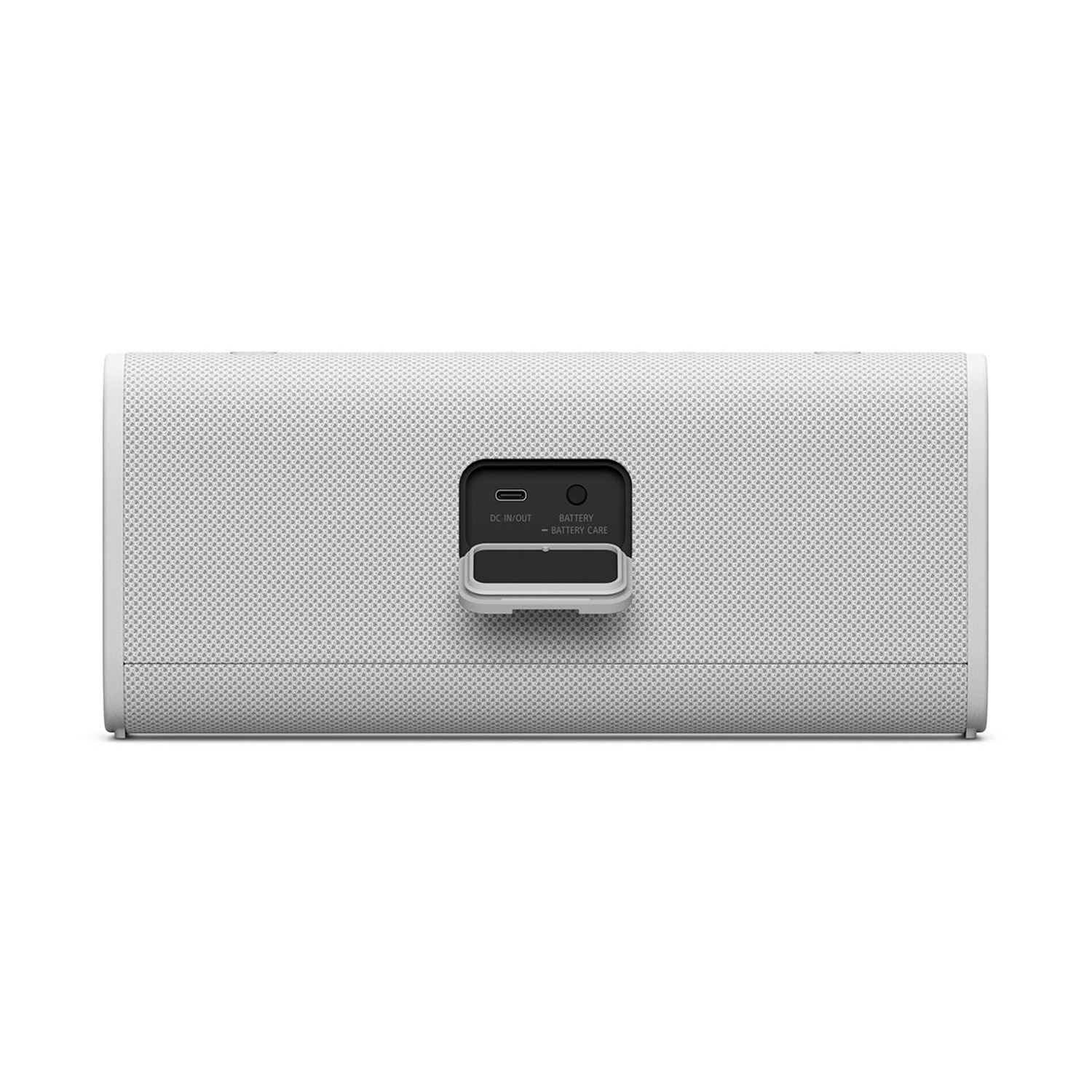 Un altoparlante bianco con un coperchio porta aperto che mostra ingresso/uscita CC e batteria.