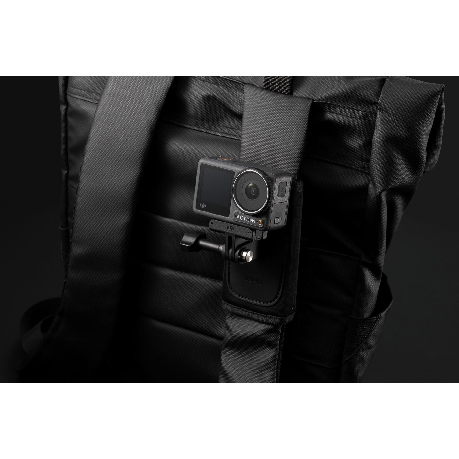 Una action camera nera è montata sulla tracolla di uno zaino nero.