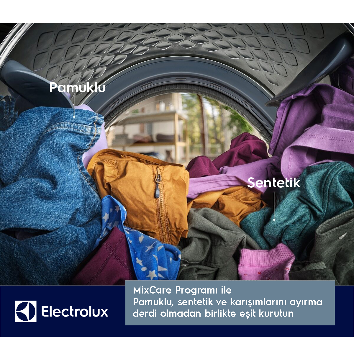 Kotun ve sentetik karışık çamaşırlarla dolu bir çamaşır makinesi tamburu, kot pantolon ve renkli giysiler dahil.