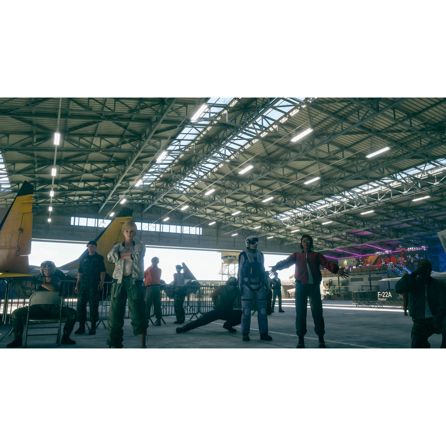 Persone in un hangar per aerei con aerei e un palco sullo sfondo.