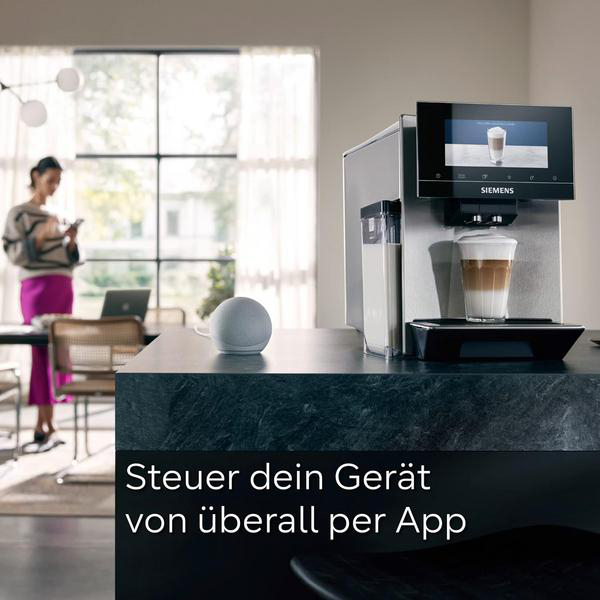 Kaffeemaschine mit Milchgetränk, Sprachassistent und Frau mit Handy.