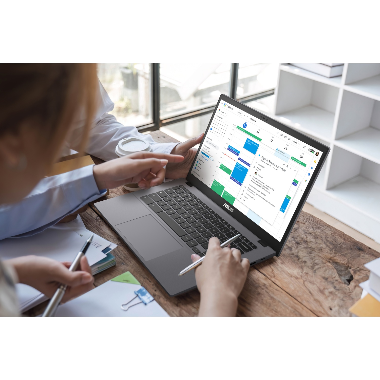 Persone mostrano un laptop con schermo calendario. Le mani digitano sulla tastiera.