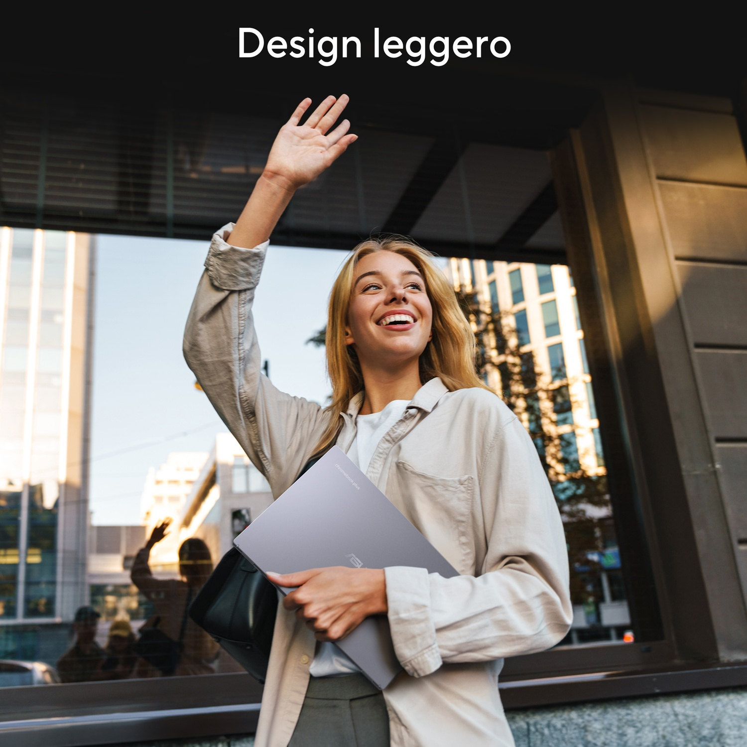 Una donna saluta e tiene un laptop in città.
