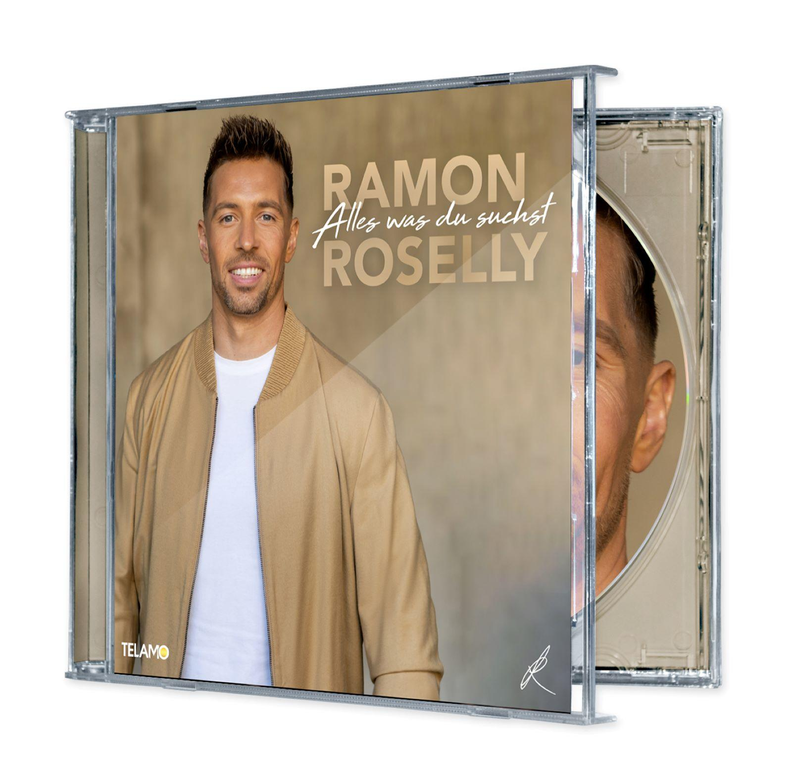 Ein Mann in einer beige Jacke lacht vor einem neutralen Hintergrund mit CD-Titel.