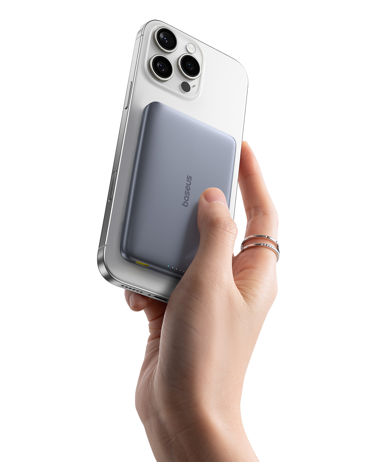 Una mano sostiene un teléfono inteligente blanco con un dispositivo de batería externo gris acoplado.
