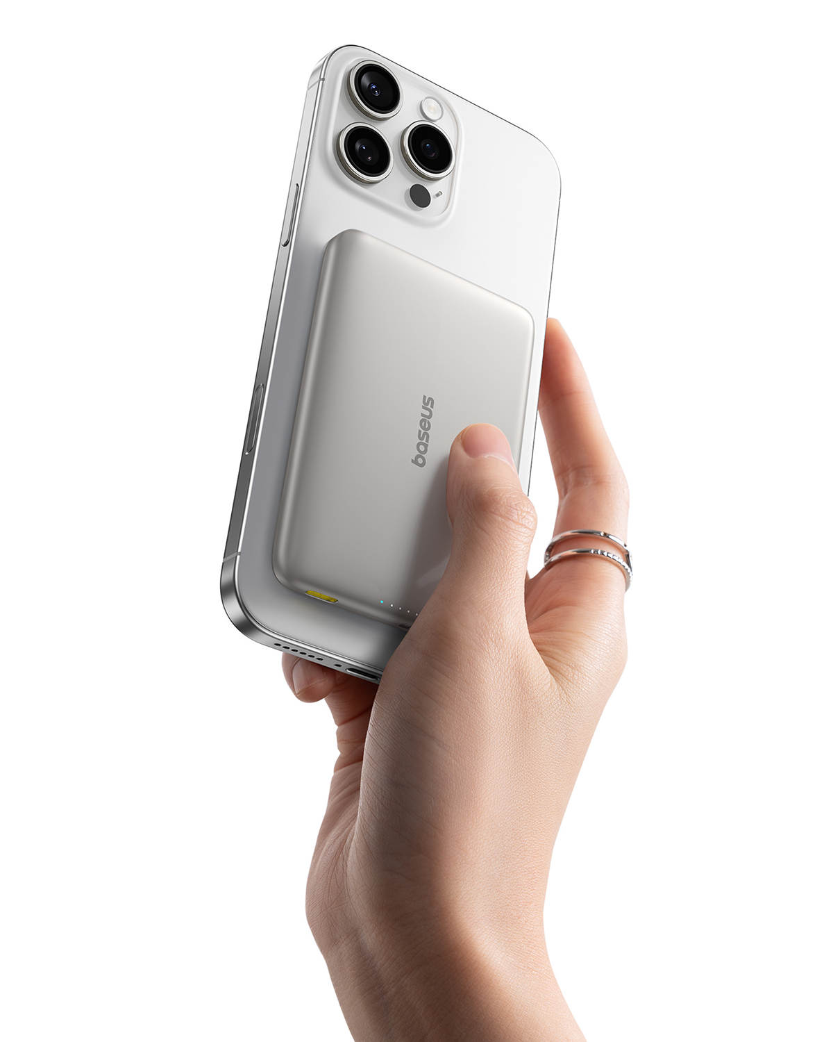 Una mano sostiene un iPhone blanco con una batería plateada acoplada.