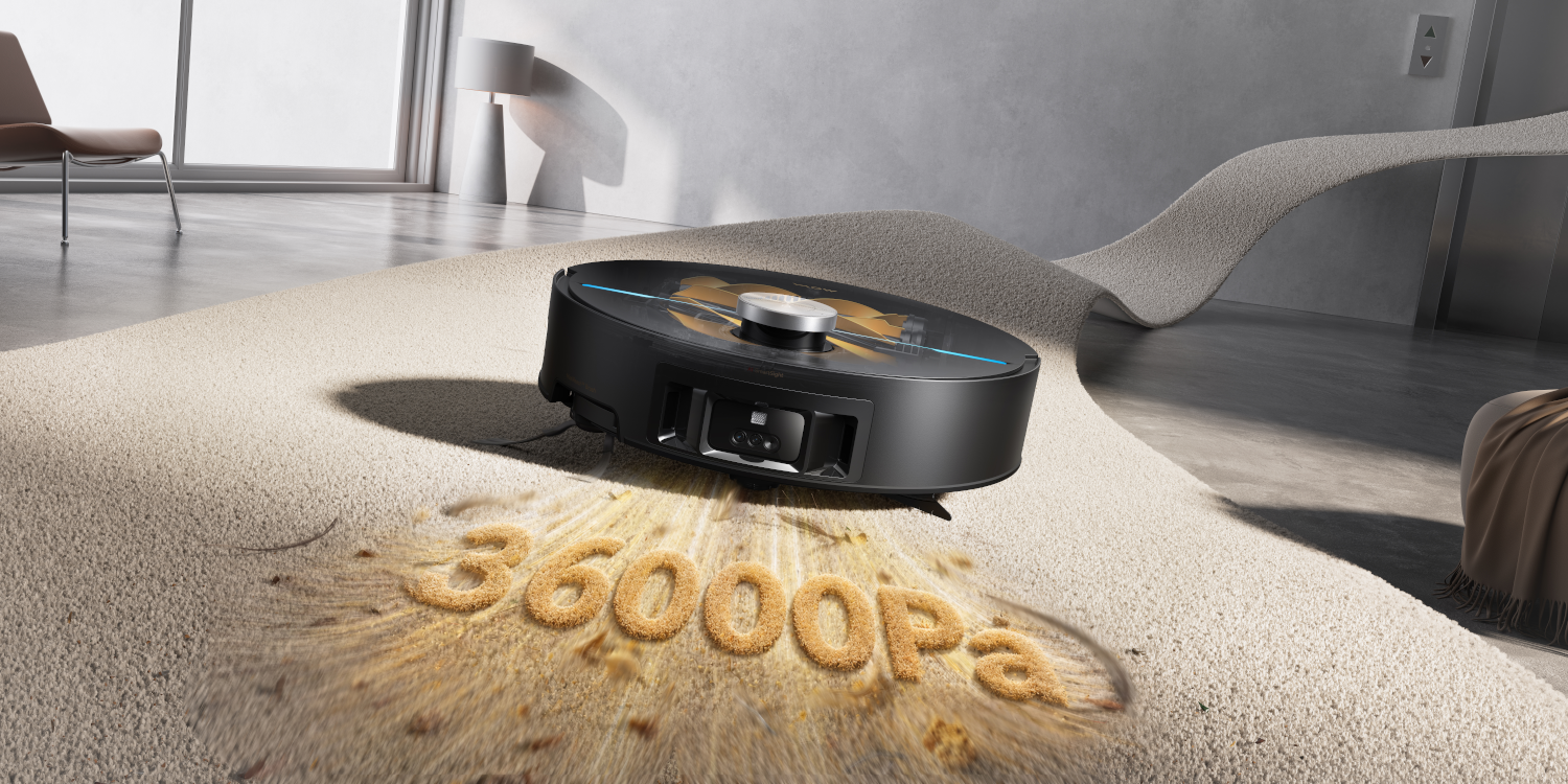 Un robot aspirapolvere nero aspira 36000 Pa su un tappeto.