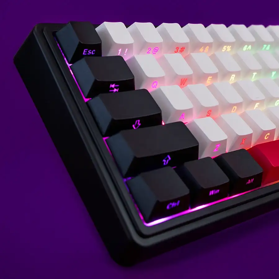 Egy fekete billentyűzet közeli felvétele lila és fehér gombokkal, RGB világítással.