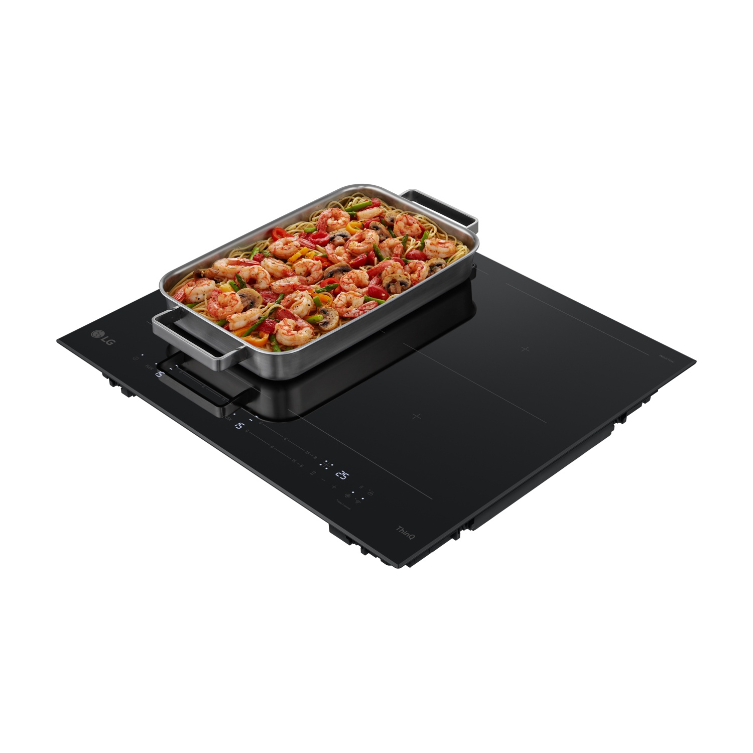 Una teglia con gamberi, pasta e verdure su un piano cottura a induzione nero.