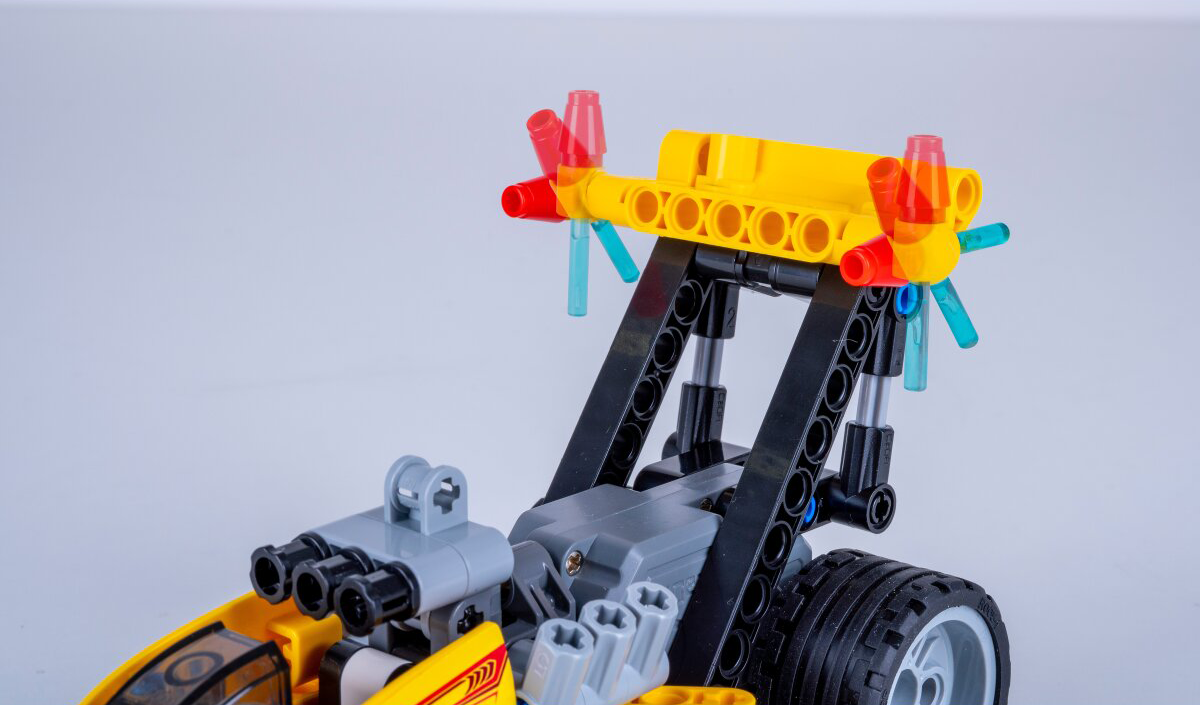 Egy sárga Lego jármű fekete és szürke részekkel és átlátszó kék propellerrel.