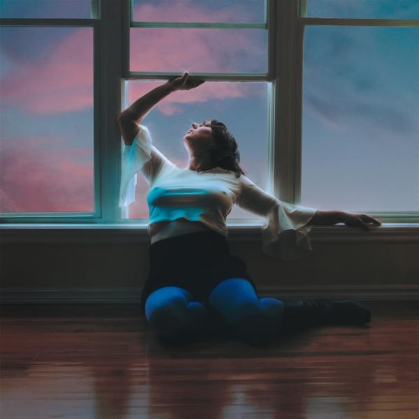 Frau sitzt auf dem Boden vor einem Fenster mit rosa und blauen Wolken.