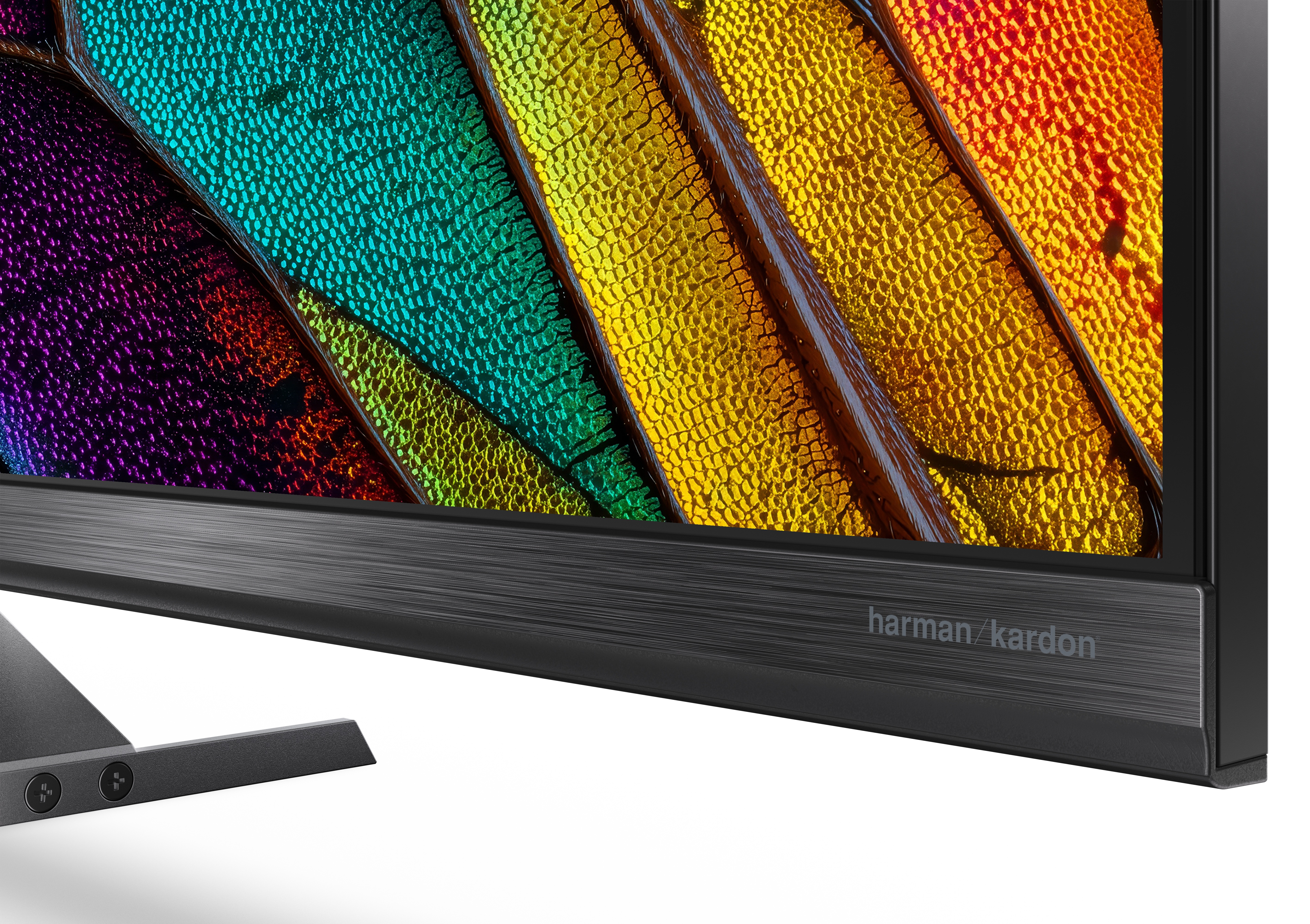 Monitor z kolorowym, makro-zdjęciem wzoru liścia i logo Harman Kardon.