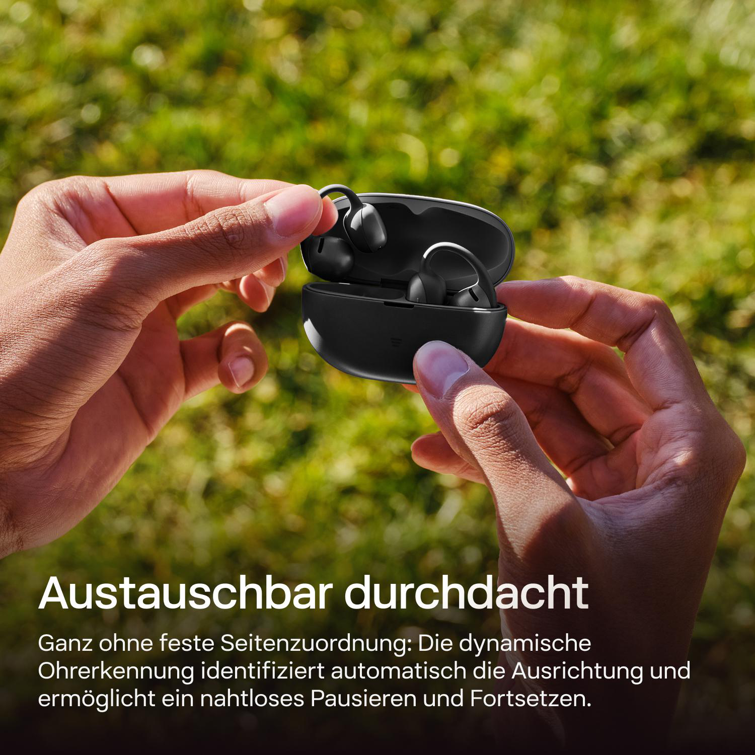Eine Hand hält ein schwarzes Ladecase mit kabellosen Ohrhörern darin.