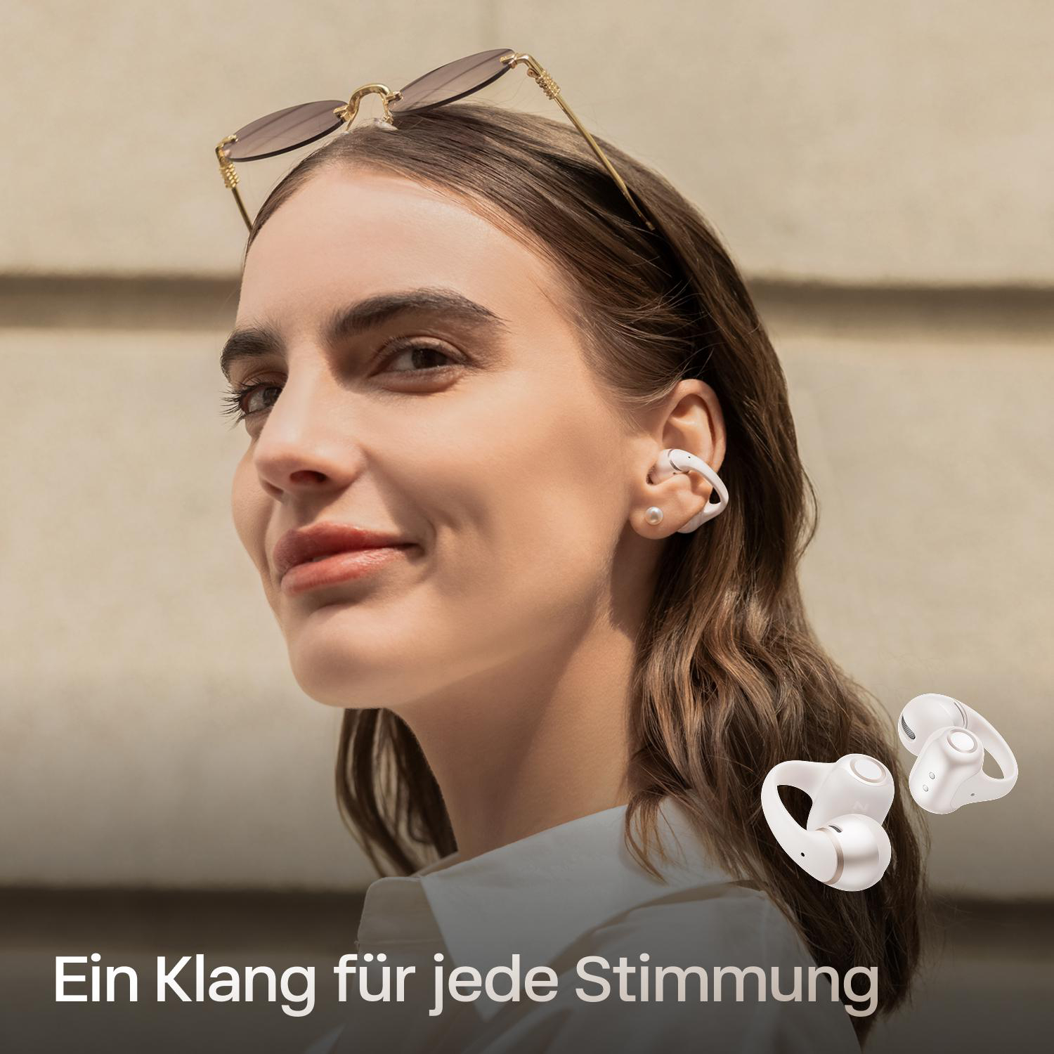 Eine Frau mit Sonnenbrille trägt weiße Ohrhörer. Daneben sind zwei weiße Ohrhörer.