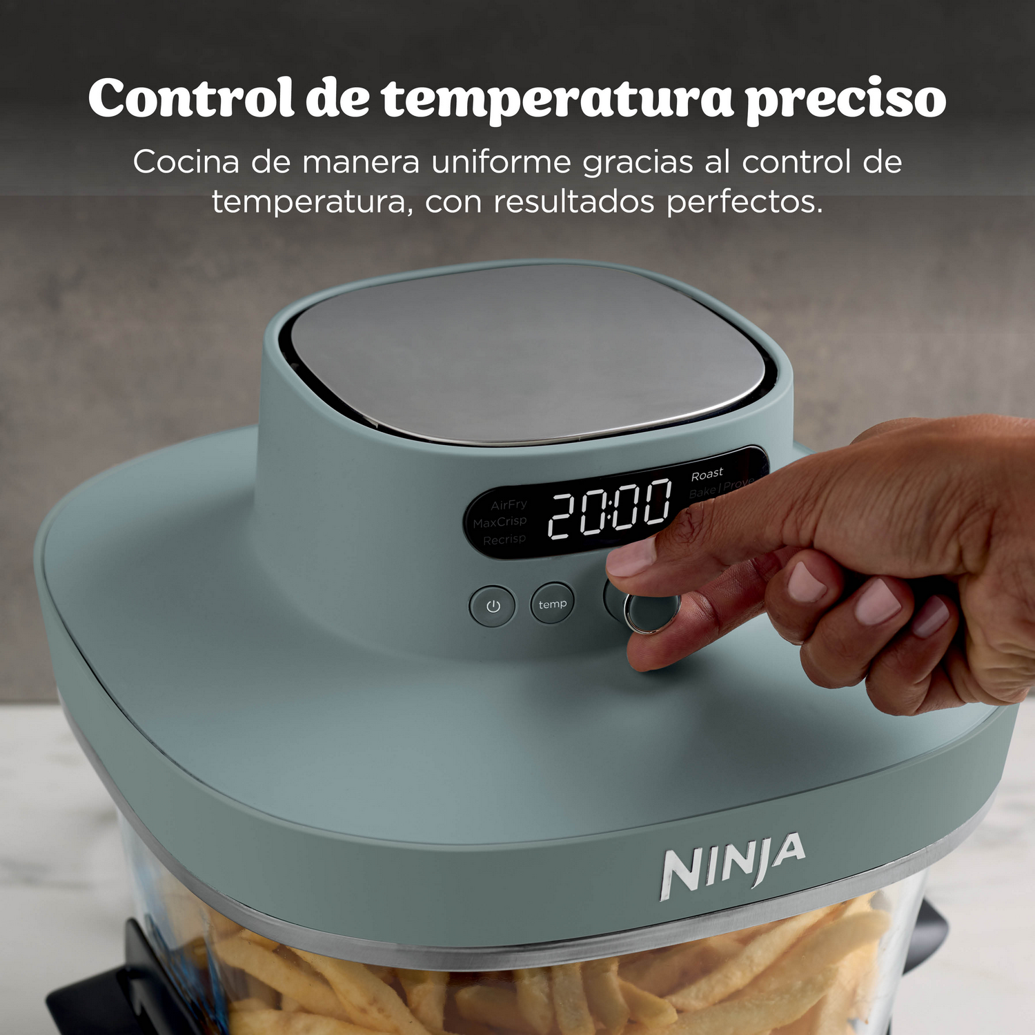 Una mano ajusta una freidora de aire Ninja gris con papas fritas dentro. La pantalla digital muestra 20:00.