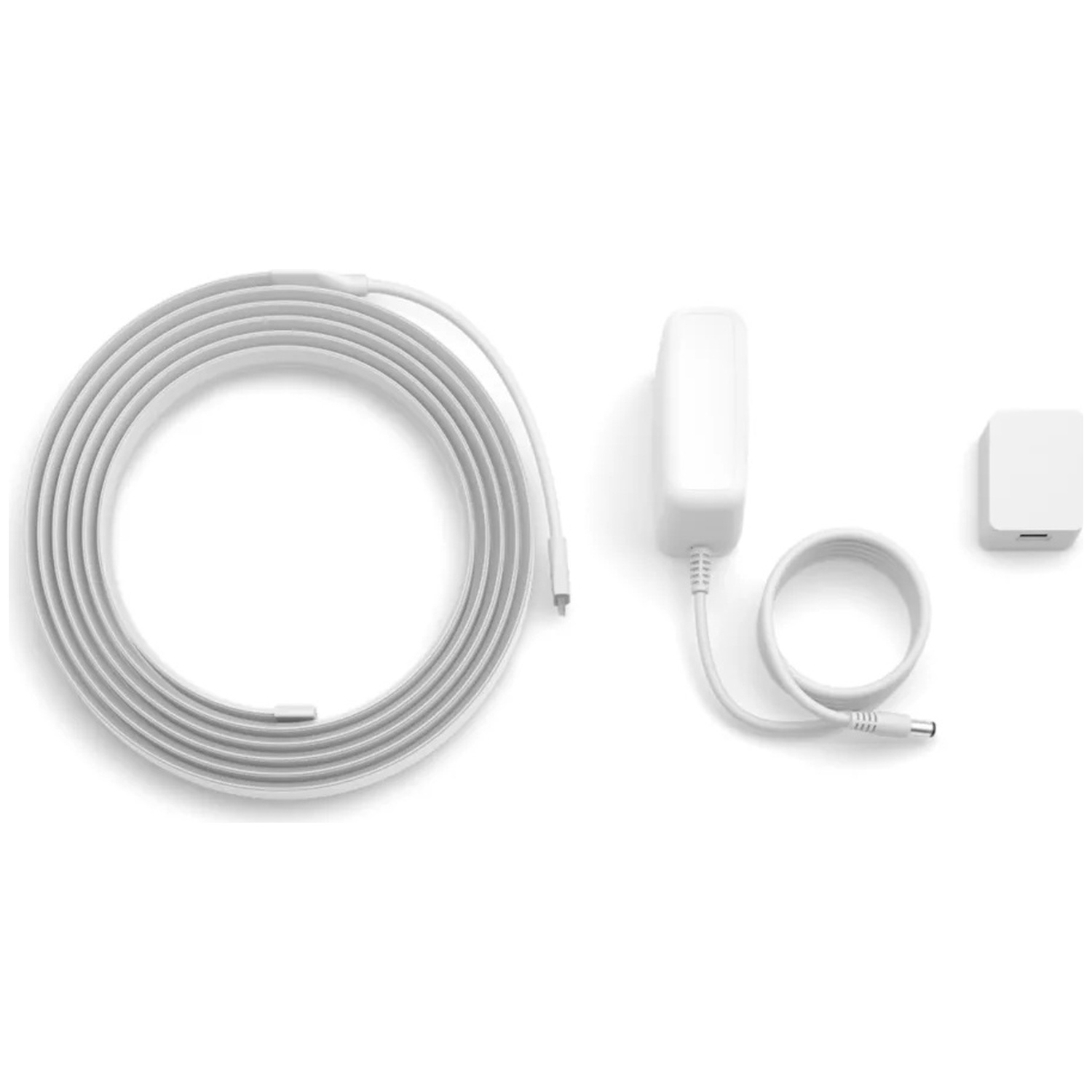 Une bande LED blanche, un adaptateur secteur et un petit cube blanc sur fond blanc.