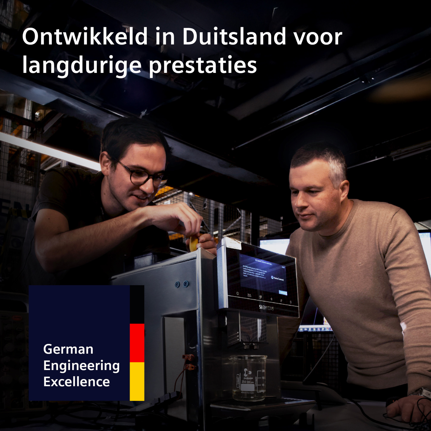 Two men work on a machine, with German flag and text.