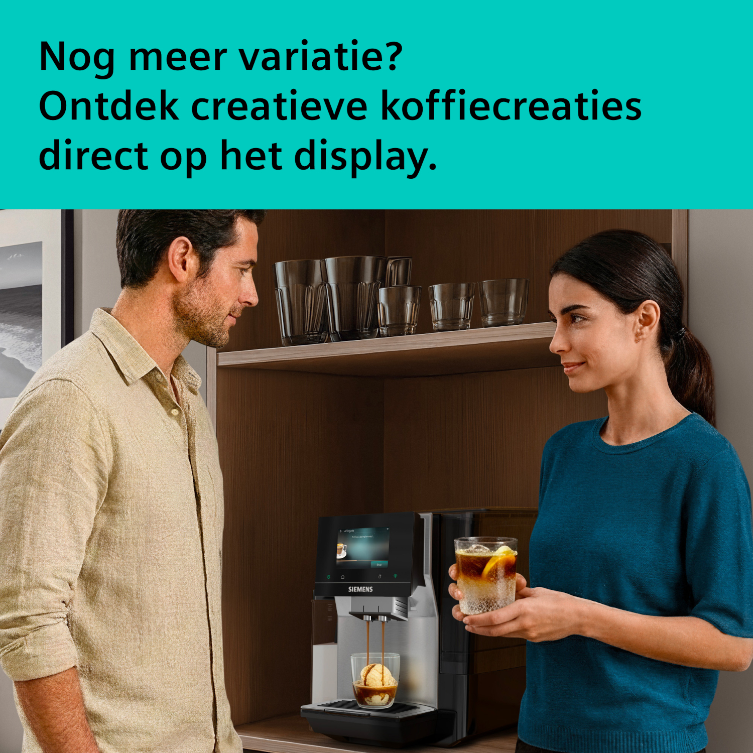 Man and woman look at a coffee machine making coffee.