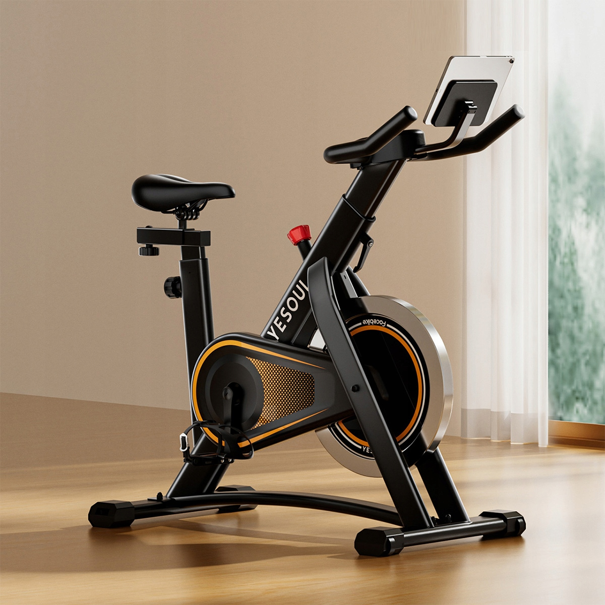 Czarny rower stacjonarny z uchwytem na tablet i pomarańczowymi akcentami.