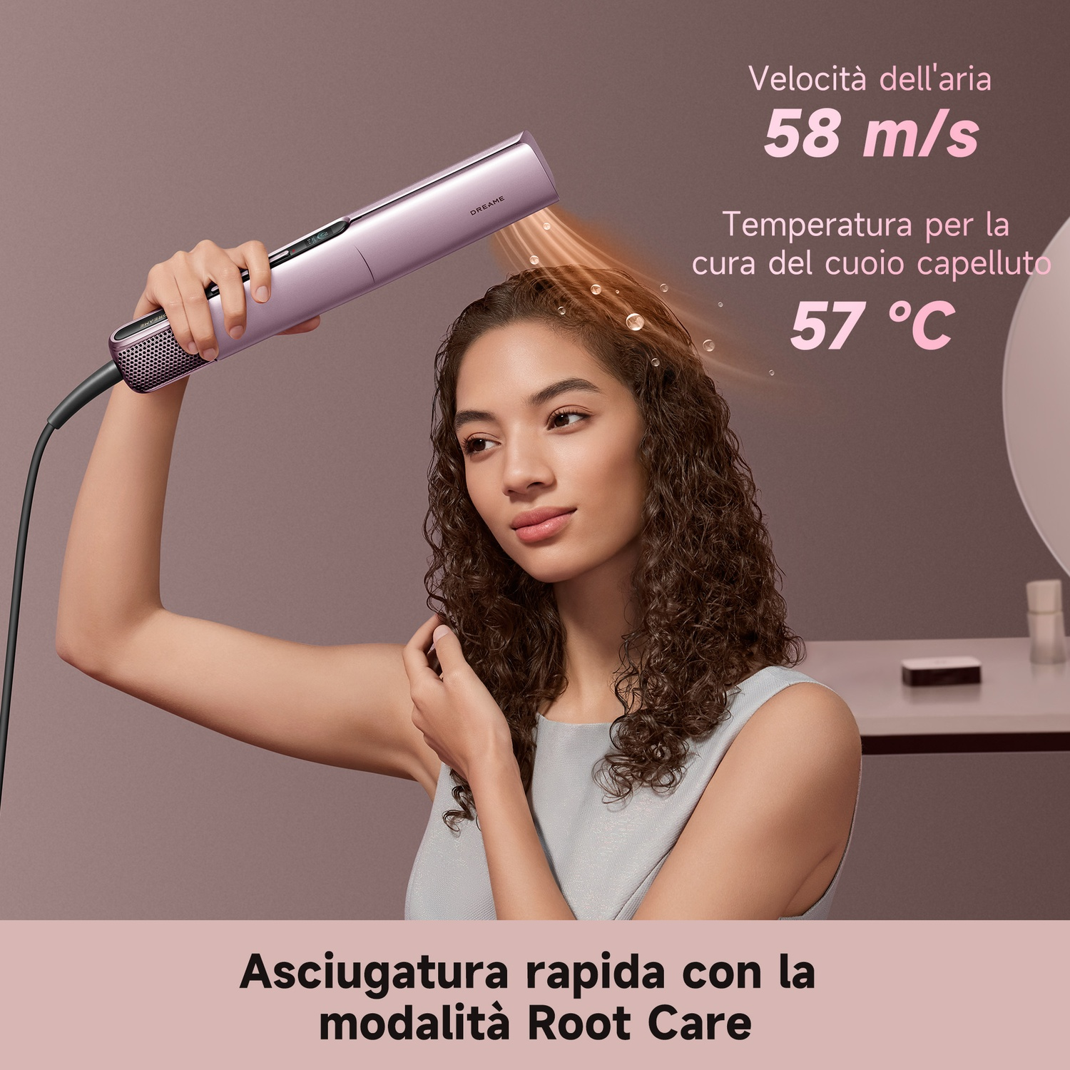 Una donna usa un asciugacapelli rosa Dreame sui suoi capelli ricci.