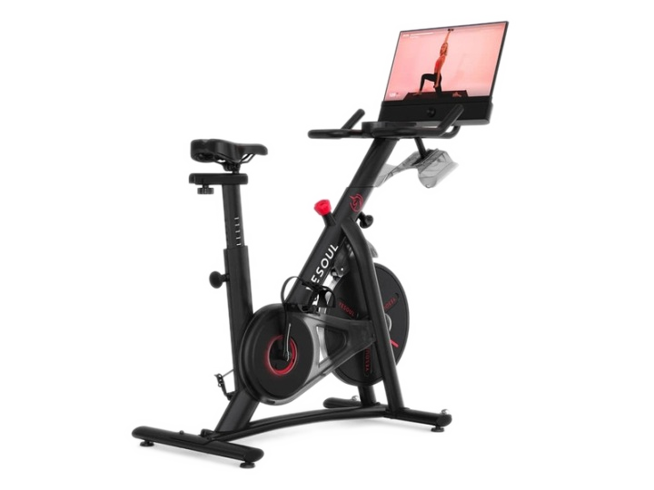 Czarny rower stacjonarny z ekranem pokazującym pozę do jogi.