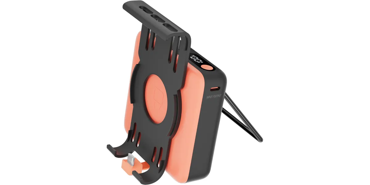 Ein korallenfarbenes Powerbank-Gehäuse mit schwarzem Ständer und Halterung.