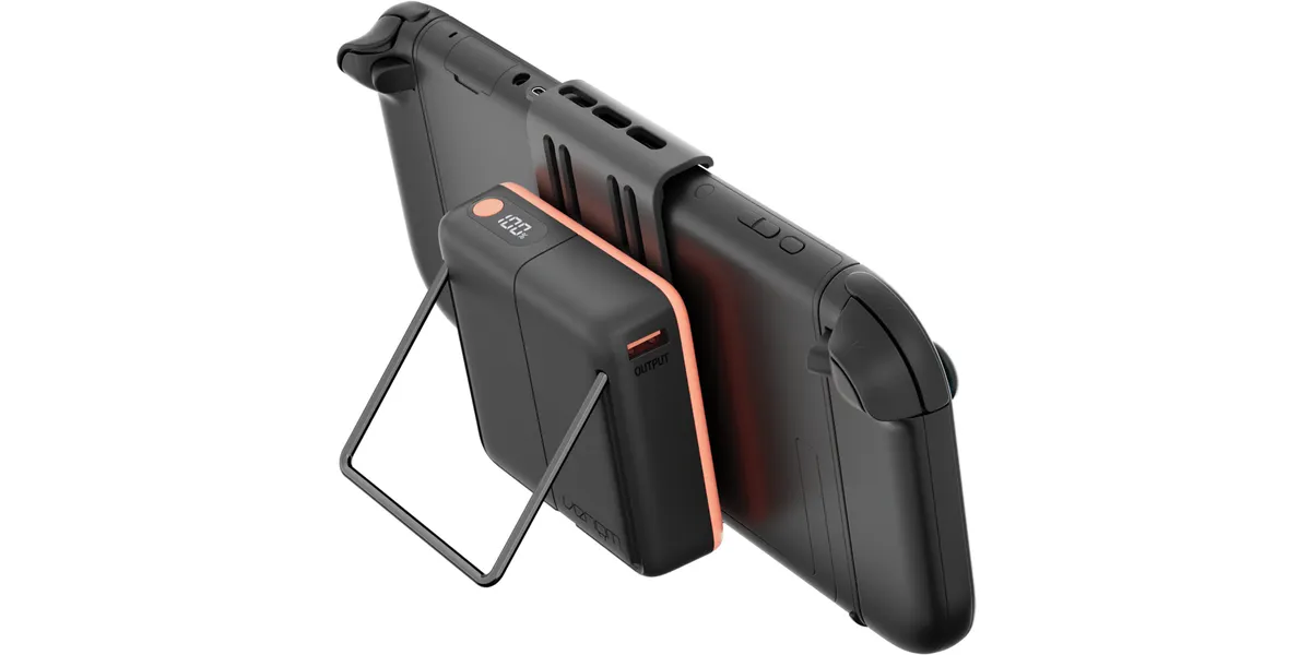 Ein schwarzes Handheld-Gerät mit einem schwarzen Powerbank-Aufsatz mit orangenem Rand und Ständer.