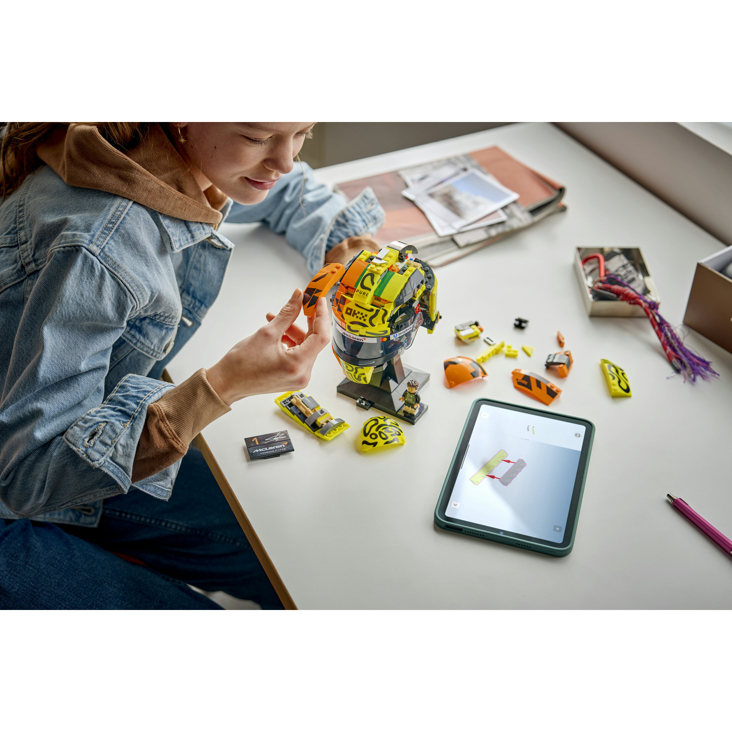 Una ragazza costruisce un casco Lego usando le istruzioni su un tablet.