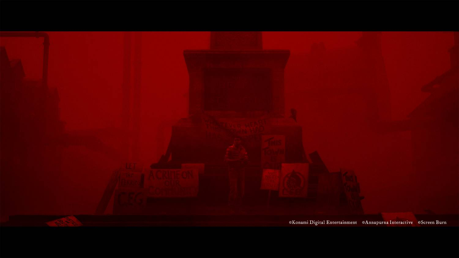 Un hombre frente a un monumento con pancartas de protesta en una escena roja y brumosa.