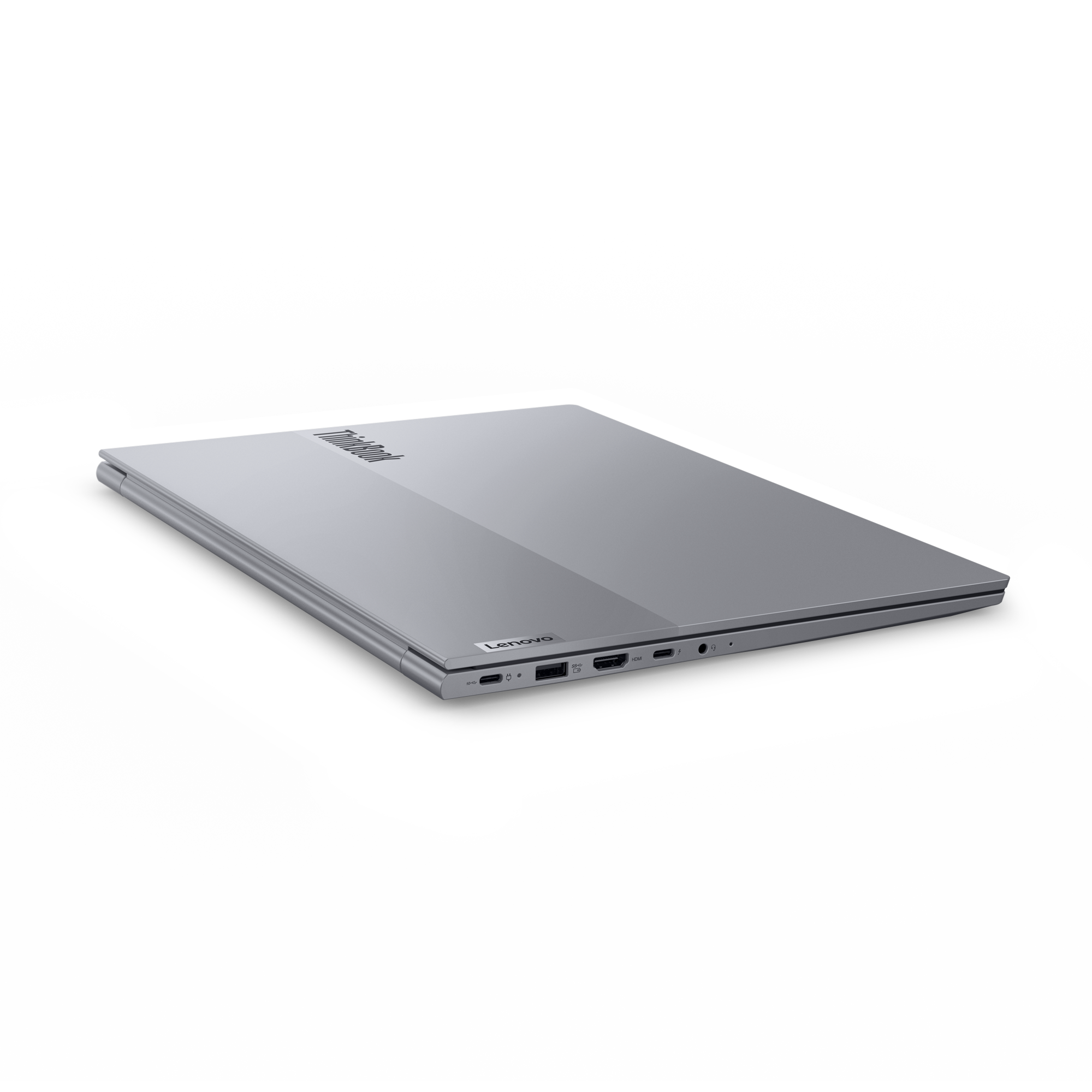 Srebrny laptop z zamkniętą pokrywą, widoczne porty z boku.