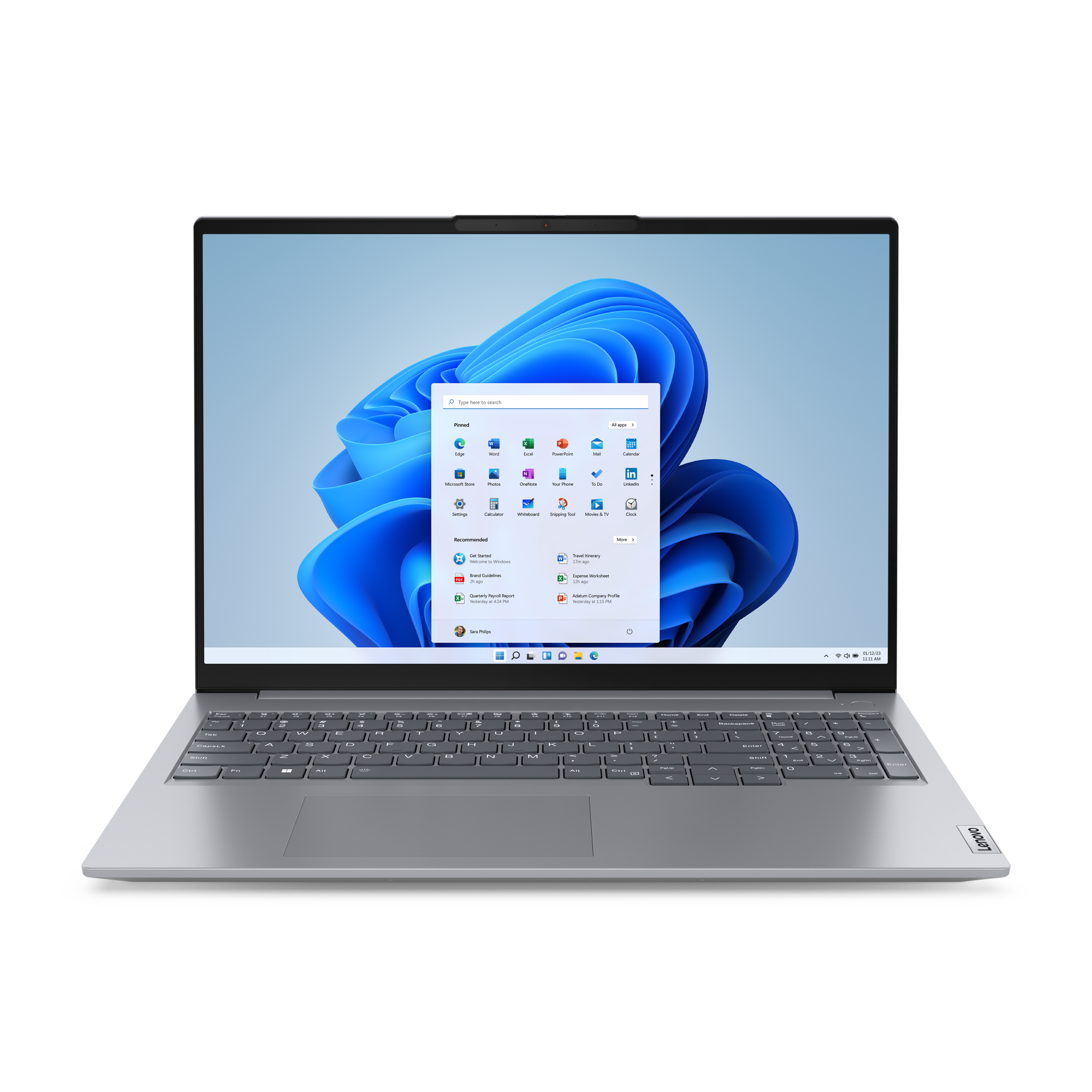 Srebrny laptop z otwartym menu Start Windows 11 i niebieską tapetą falistą.